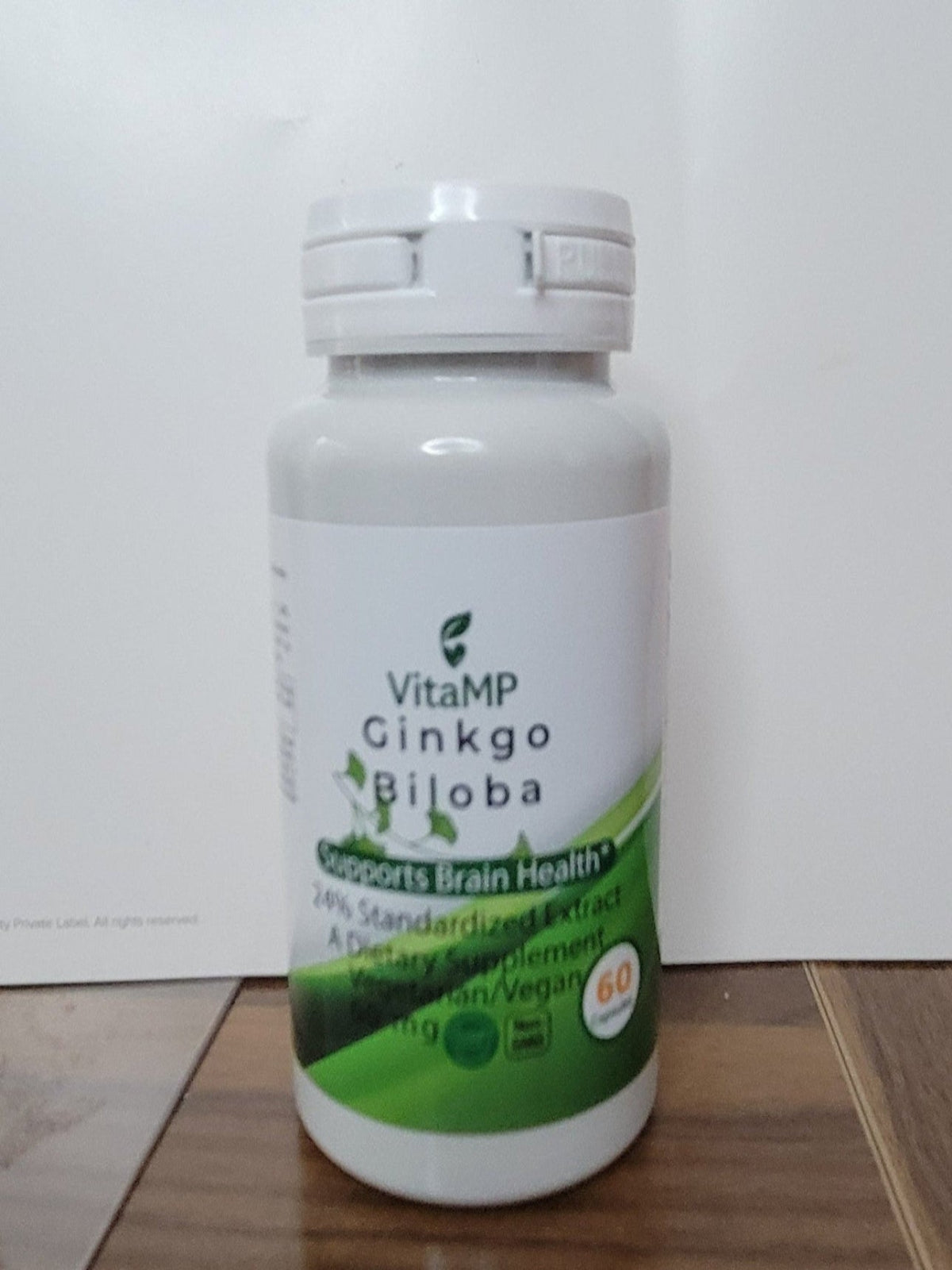 VitaMP Ginkgo Biloba supplement bottle on a wooden surface with a white background
